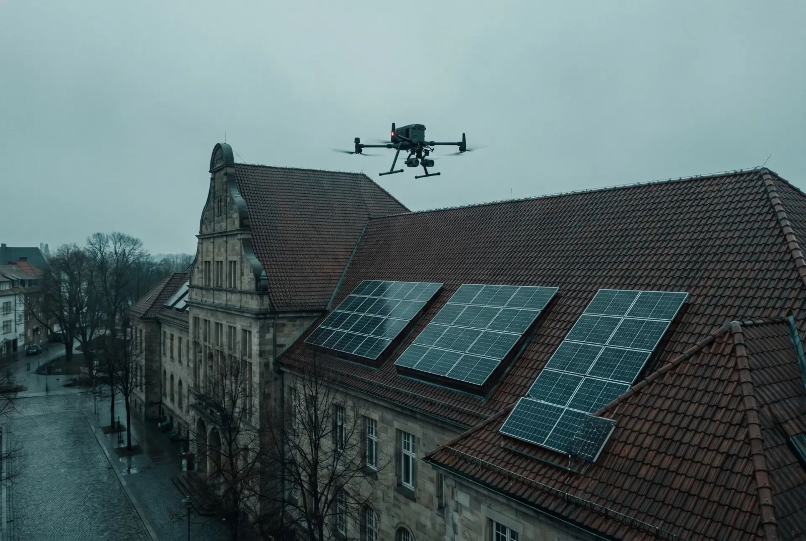 Drohne über einem Gebäudedach mit Photovoltaikmodulen